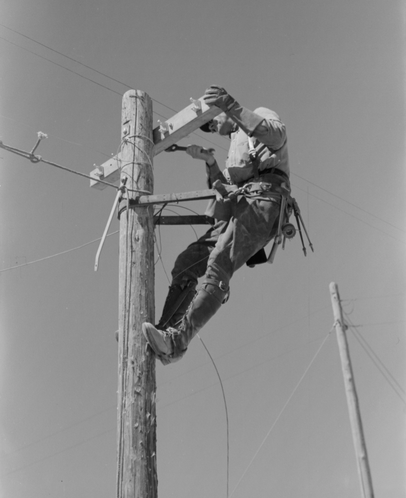 Lineman on telephone pole at the Casa Grande Valley Farms, Pinal County, Arizona (Libary of Congress, LC-USF33-012683-M5)